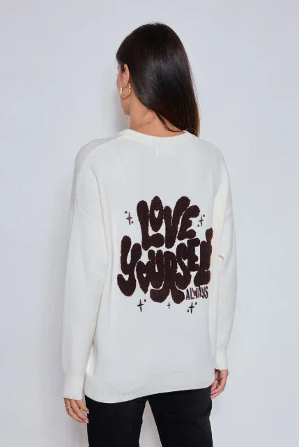 Femme de dos portant un pull blanc avec l'inscription Love Yourself Always, prêt-à-porter éthique