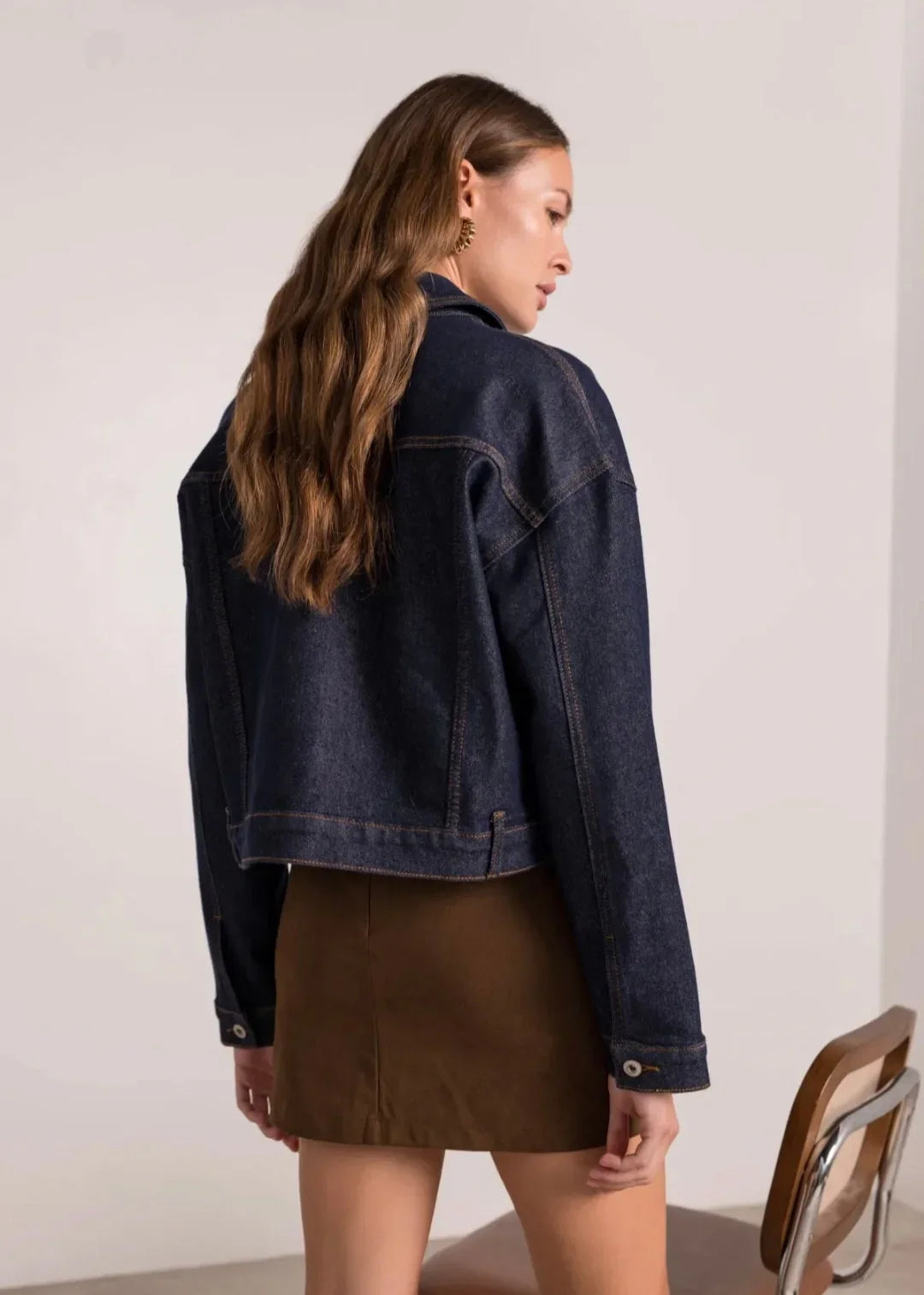 Femme de dos portant une veste en jean oversize et une jupe marron, mode éthique tendance