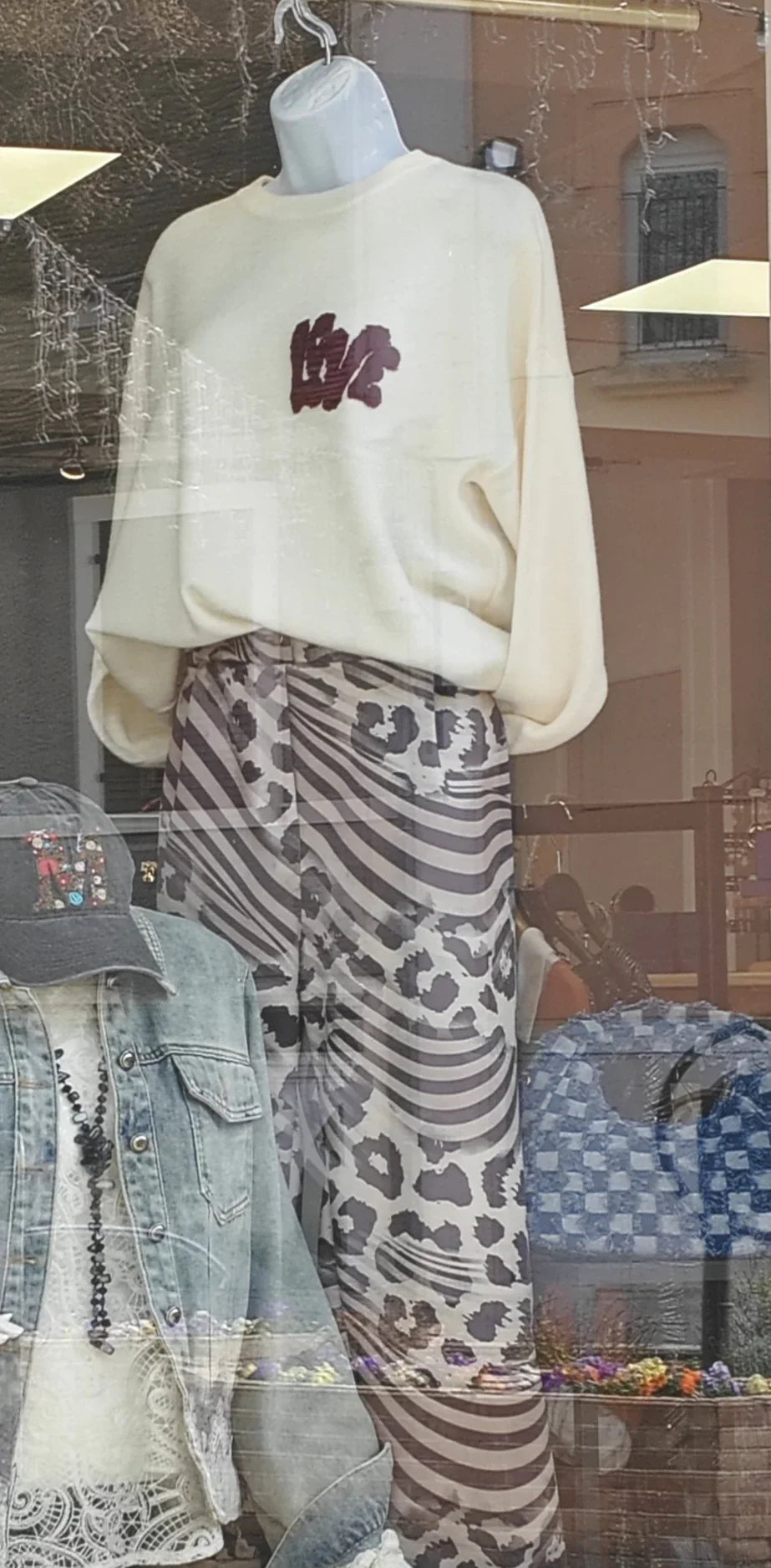 Pantalon oversize femme à motifs marron et crème, style tendance, vitrine de boutique.